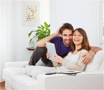couple sitting on a couch happy with their bill